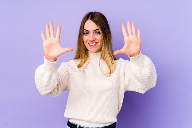 Mujer caucásica joven que muestra el número diez con las manos.