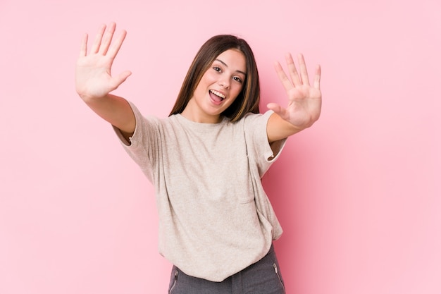 Mujer caucásica joven que presenta mostrando el número diez con las manos.