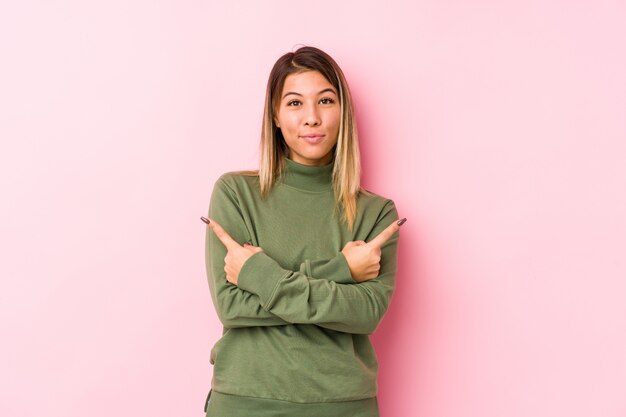 La mujer caucásica joven que presenta puntos aislados de lado, está intentando elegir entre dos opciones.