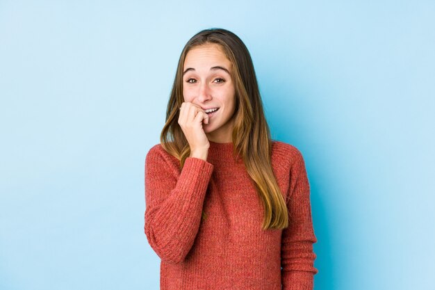 Mujer caucásica joven que presenta las uñas penetrantes aisladas, nerviosas y muy ansiosas.