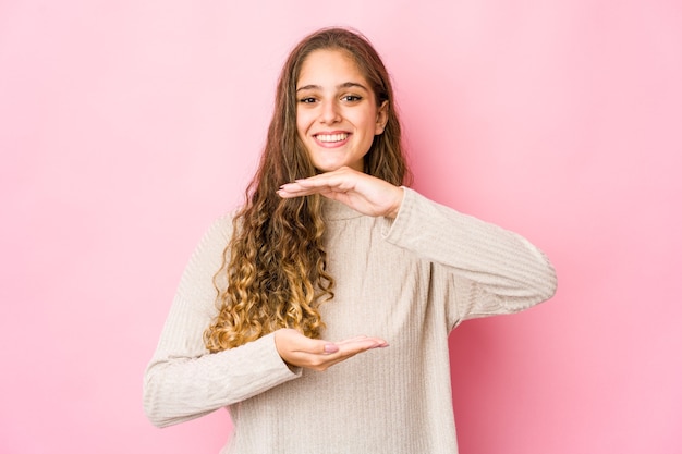 Mujer caucásica joven que sostiene algo con ambas manos, presentación del producto.