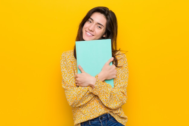 Mujer caucásica joven que sostiene algunos cuadernos