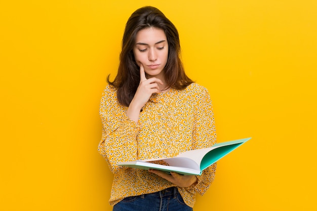 Mujer caucásica joven que sostiene algunos cuadernos