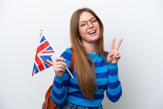 Mujer caucásica joven que sostiene una bandera del Reino Unido aislada en el fondo blanco