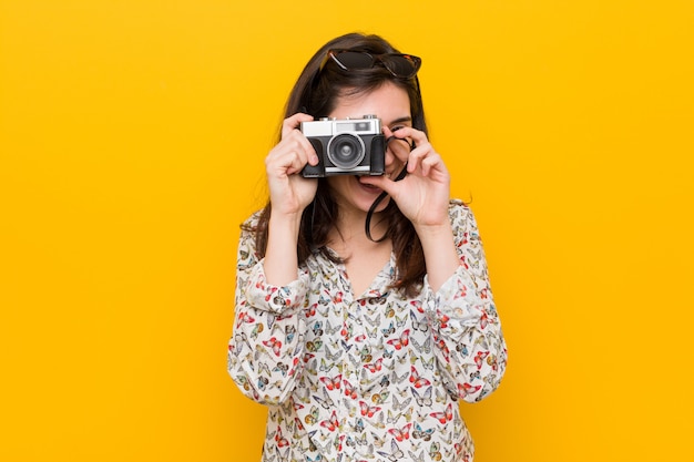 Mujer caucásica joven que sostiene una cámara vintage