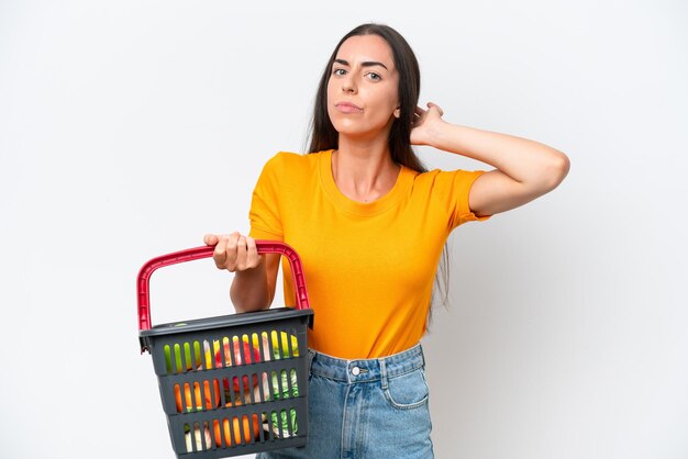 Foto mujer caucásica joven que sostiene una cesta de compras llena de comida