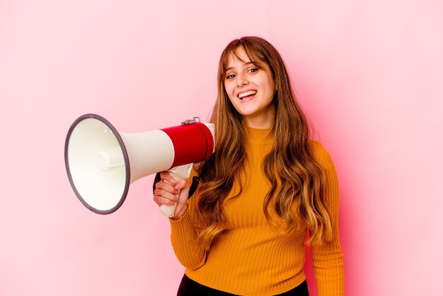 Mujer caucásica joven que sostiene un megáfono aislado feliz, sonriente y alegre.