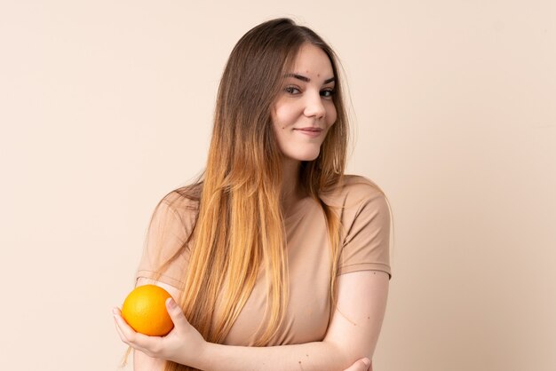 Mujer caucásica joven que sostiene una naranja