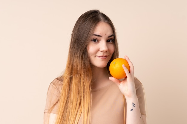 Mujer caucásica joven que sostiene una naranja