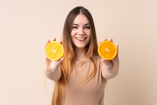 Mujer caucásica joven que sostiene una naranja