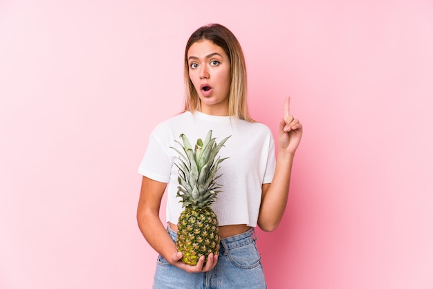 Mujer caucásica joven que sostiene una piña que tiene una gran idea, concepto de creatividad.