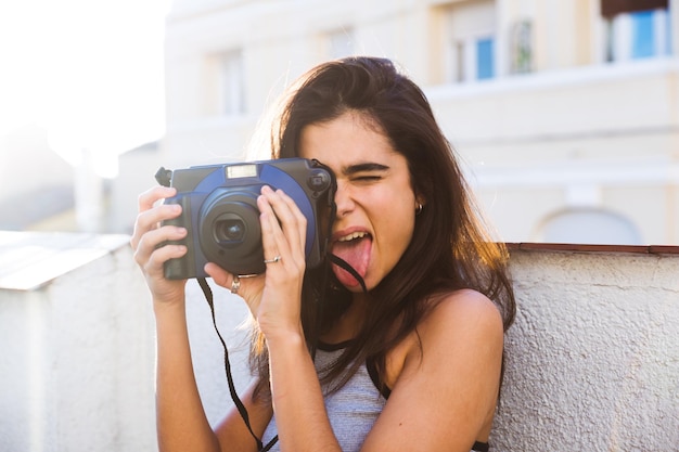 Mujer caucásica joven que usa una cámara de fotos