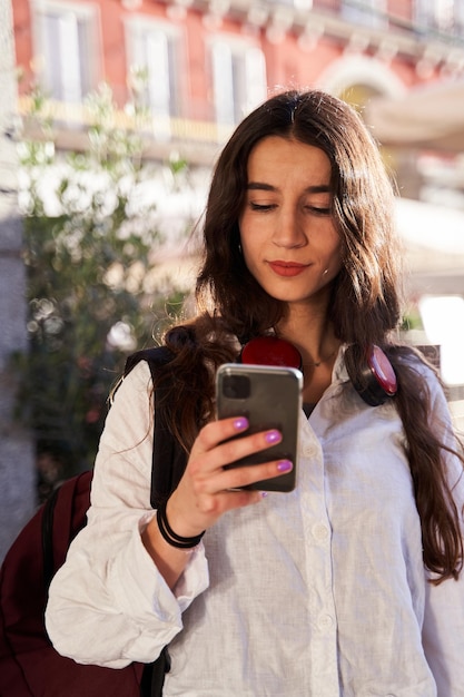 Mujer caucásica joven que usa su teléfono móvil