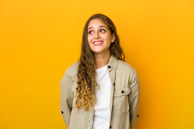 Mujer caucásica joven relajada y feliz riendo, cuello estirado mostrando los dientes.