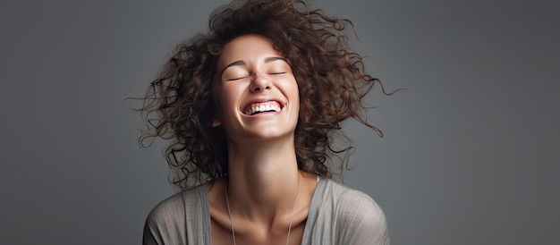 Mujer caucásica joven riendo con los ojos cerrados aislado sobre fondo gris Emociones positivas