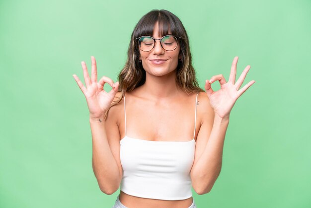 Foto mujer caucásica joven sobre un fondo aislado en pose zen