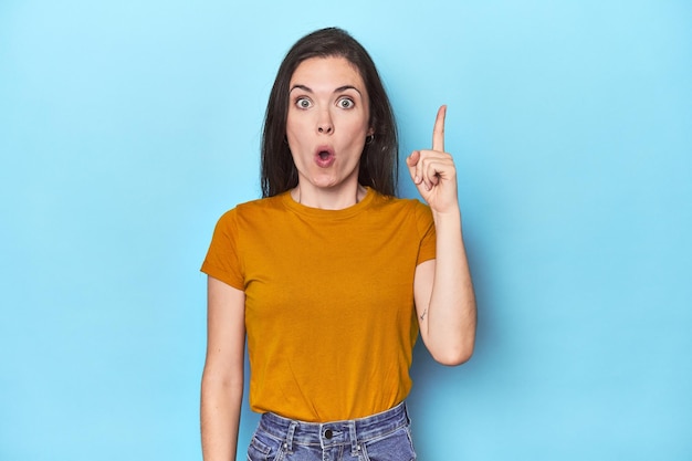 Mujer caucásica joven sobre fondo azul con un concepto de inspiración idea