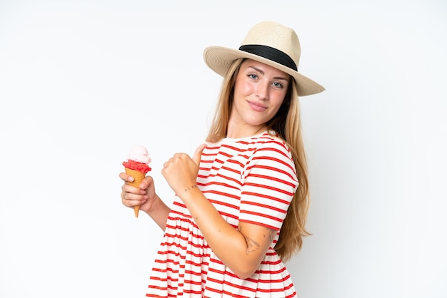 Mujer caucásica joven sosteniendo un helado de cucurucho aislado sobre fondo blanco orgullosa y satisfecha