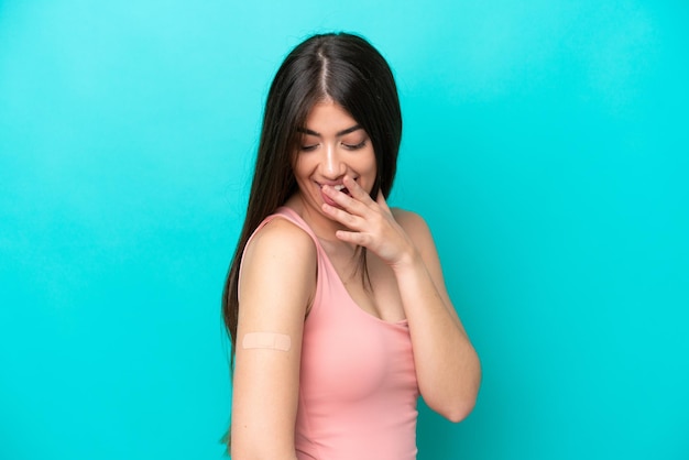 Mujer caucásica joven con tiritas aisladas de fondo azul con expresión facial sorprendida y sorprendida