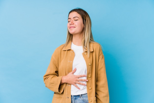 Foto la mujer caucásica joven toca la panza, sonríe suavemente, comiendo y concepto de la satisfacción.