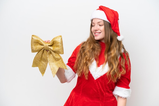 Mujer caucásica joven con vestido de Navidad sosteniendo arco de Navidad aislado sobre fondo blanco con expresión feliz