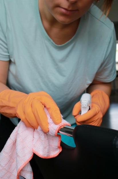 mujer caucásica limpiando en casa guantes de goma naranja, limpieza de primavera