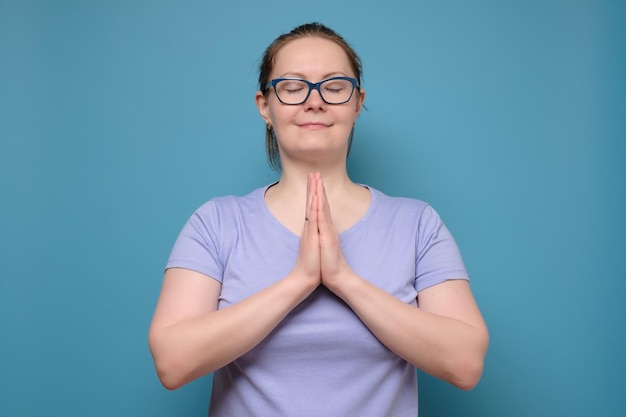 Mujer caucásica madura con gafas cogidas de la mano con los ojos cerrados