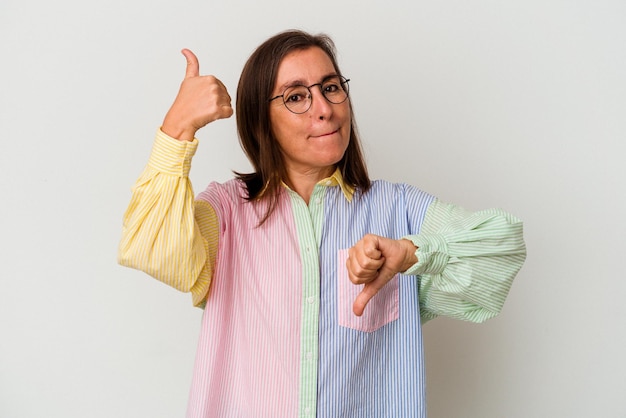 Foto mujer caucásica de mediana edad aislada de fondo blanco que muestra los pulgares hacia arriba y hacia abajo es difícil elegir el concepto