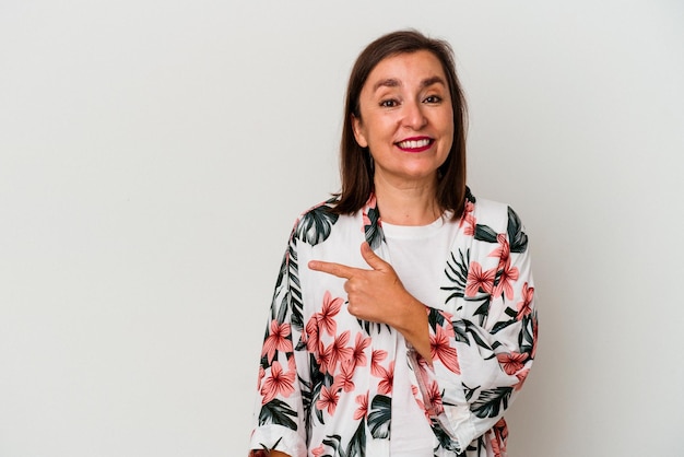 Mujer caucásica de mediana edad aislada de fondo blanco sonriendo y señalando a un lado, mostrando algo en el espacio en blanco.