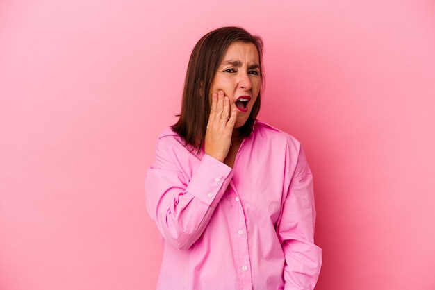 Mujer caucásica de mediana edad aislada de fondo rosado con un fuerte dolor de dientes, dolor molar.