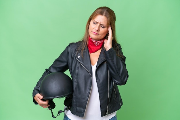 Mujer caucásica de mediana edad con casco de motocicleta sobre antecedentes aislados con dolor de cabeza