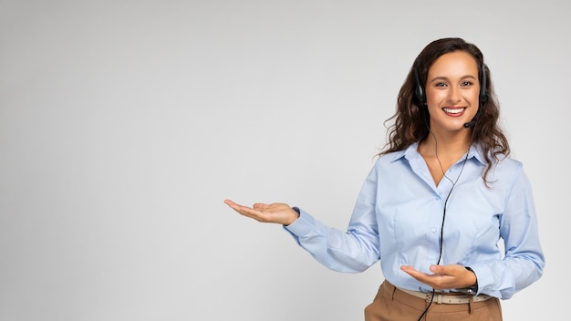 Mujer caucásica millennial positiva con ropa formal apuntando con las manos al espacio de copia