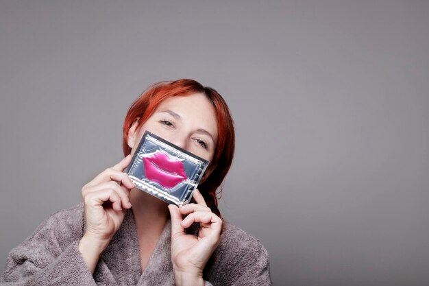 mujer caucásica mostrando un parche hidratante para los labios