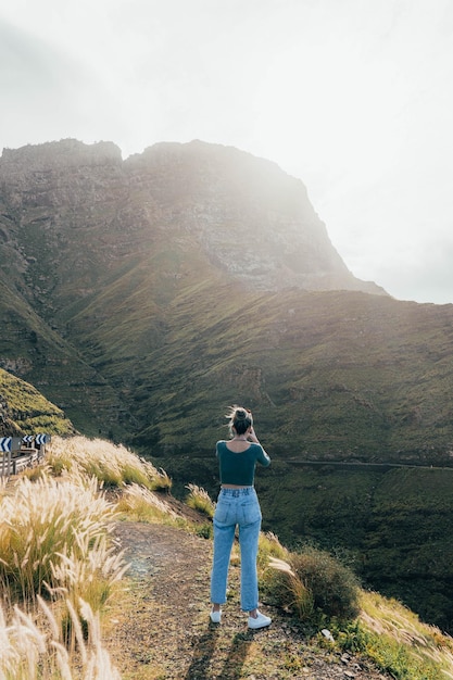 Mujer caucásica en la naturaleza tomando una foto con su teléfono inteligente