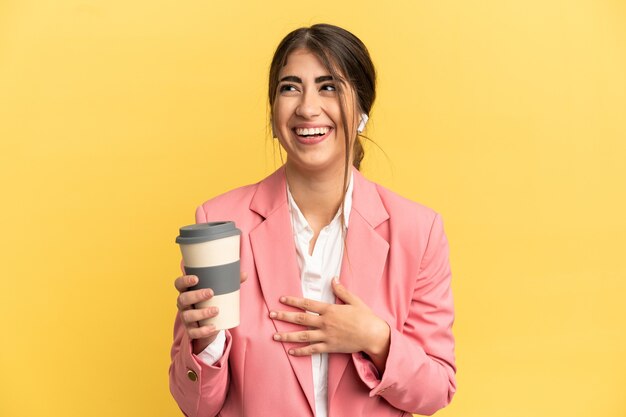 Mujer caucásica de negocios aislada sobre fondo amarillo sonriendo mucho