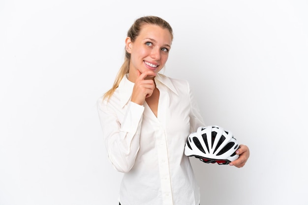 Mujer caucásica de negocios con casco de bicicleta aislado de fondo blanco mirando hacia arriba mientras sonríe