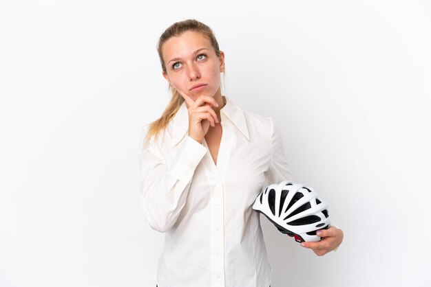 Mujer caucásica de negocios con un casco de bicicleta aislado de fondo blanco que tiene dudas