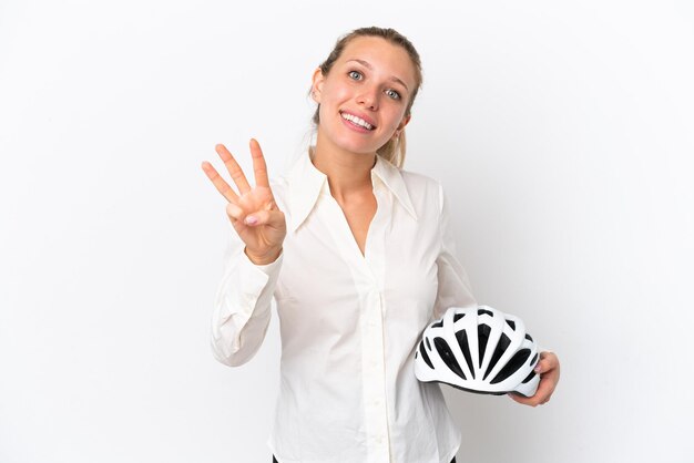 Mujer caucásica de negocios con un casco de bicicleta aislado sobre fondo blanco feliz y contando tres con los dedos