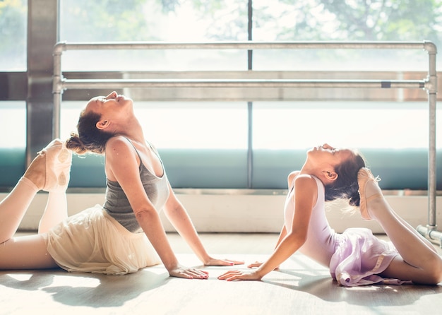 Una mujer caucásica y una niña practicando ballet