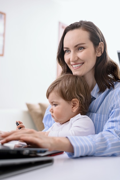 Mujer caucásica, con, niño, sentado, en, computador portatil