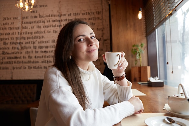 Mujer caucásica relajada beber té o café