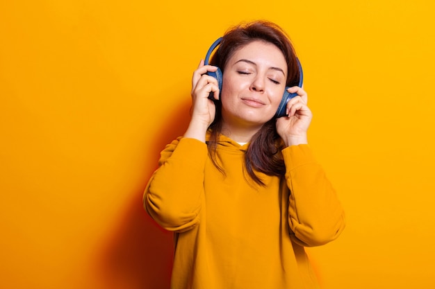 Mujer caucásica relajada disfrutando de la música en auriculares