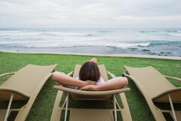 Mujer caucásica relajándose en una silla cerca del océano Índico en Sri Lanka