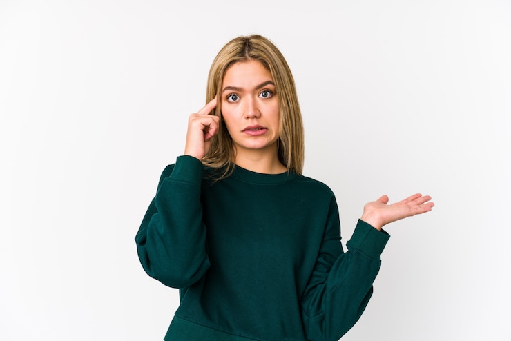Foto la mujer caucásica rubia joven aisló sostener y mostrar un producto a mano.