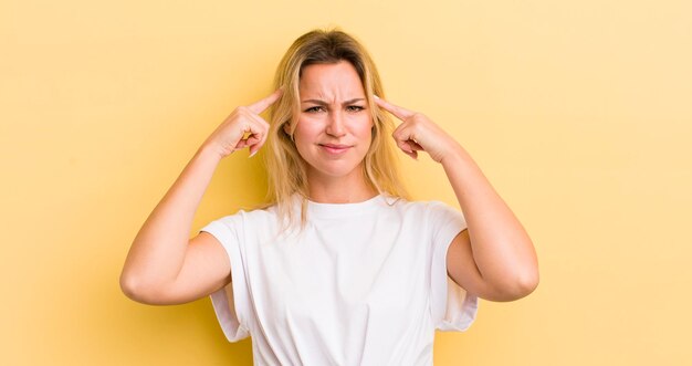 Mujer caucásica rubia con una mirada seria y concentrada haciendo lluvia de ideas y pensando en un problema desafiante