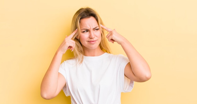 Mujer caucásica rubia que parece concentrada y piensa mucho en una idea imaginando una solución a un desafío o problema