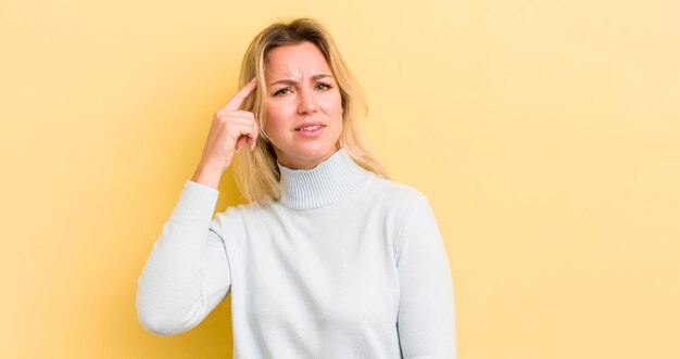 Mujer caucásica rubia que se siente confundida y perpleja mostrando que estás loca o loca