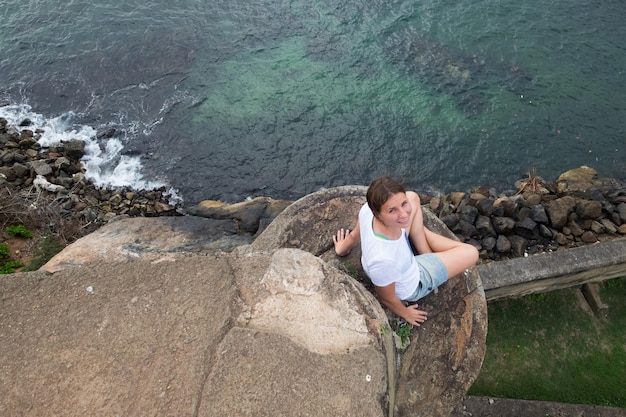 Mujer caucásica sentada en la piedra de la fortaleza en Galle Srilanka Es muy alta