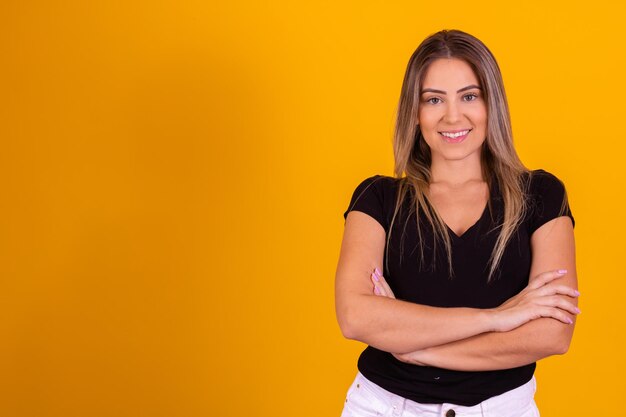 Mujer caucásica sonriendo a la cámara con los brazos cruzados