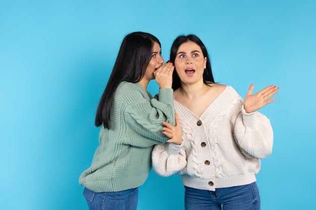 Una mujer caucásica sorprendida escucha el secreto de su hermana gemela